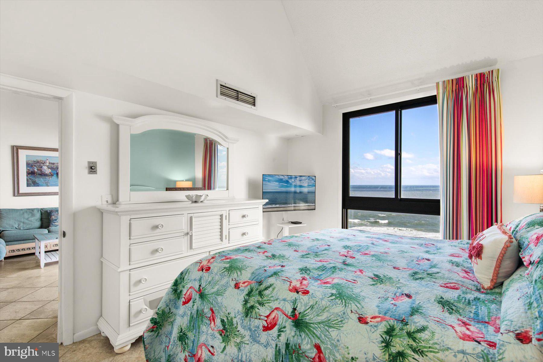 907 Georgetown House, Unit PH07 Bethany Beach, DE 19930 - Photo 23 of 48 a bedroom with a bed a dresser and mirror