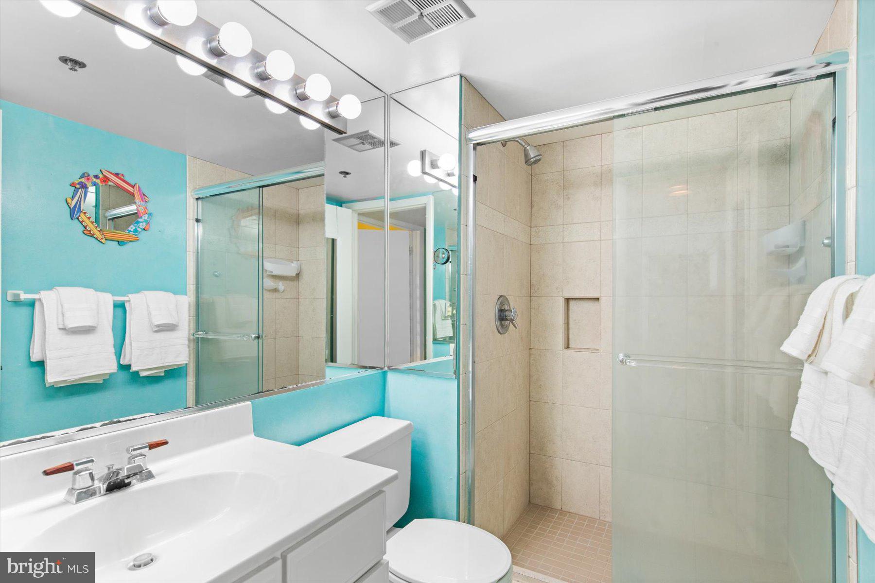 907 Georgetown House, Unit PH07 Bethany Beach, DE 19930 - Photo 25 of 48 a bathroom with a sink mirror vanity and toilet