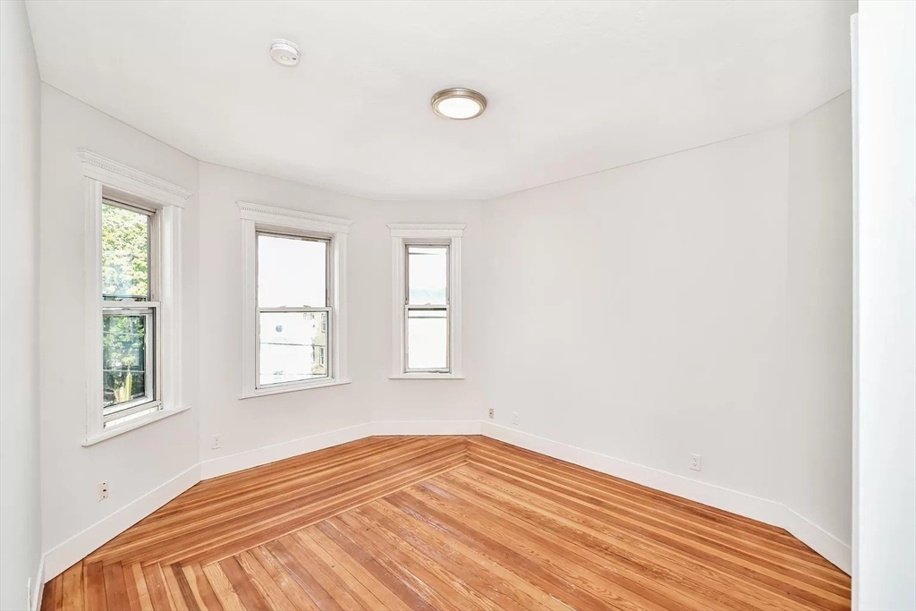 41 Dix Street, Unit 2 Boston, MA 02122 - Photo 6 of 19 an empty room with wooden floor and windows