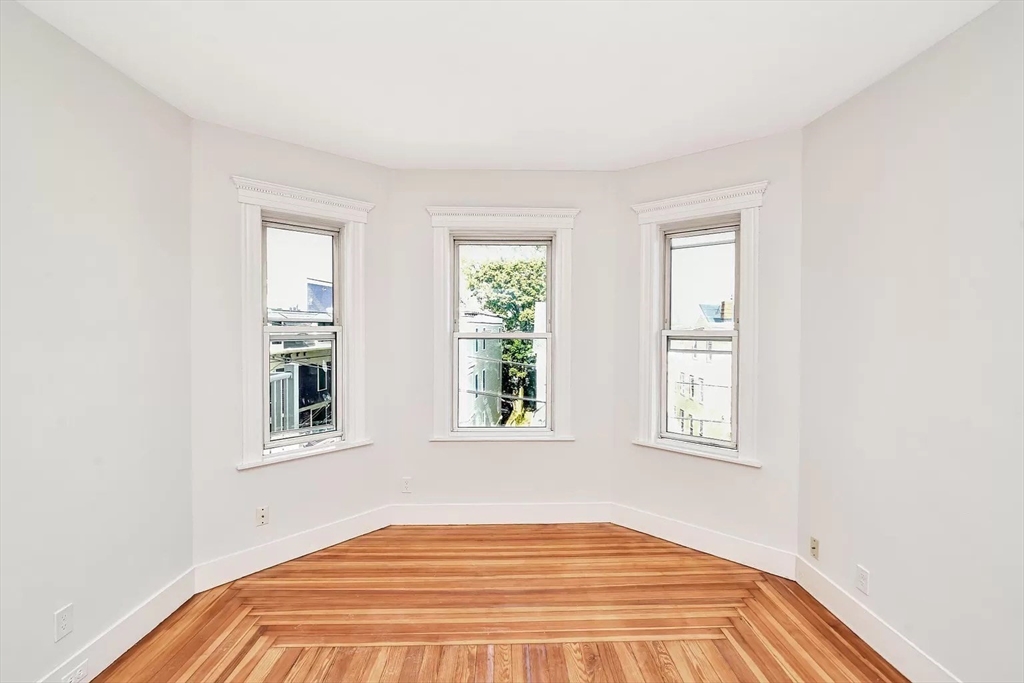 41 Dix Street, Unit 2 Boston, MA 02122 - Photo 7 of 19 an empty room with wooden floor and windows