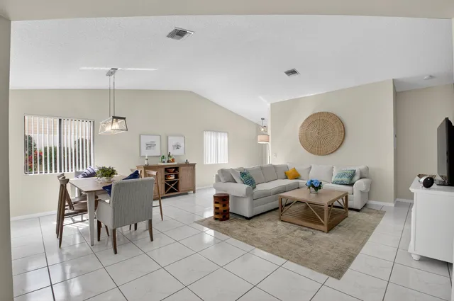 a living room with patio furniture and a chandelier