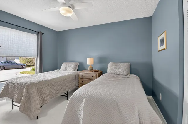 a bedroom with two beds and a large window