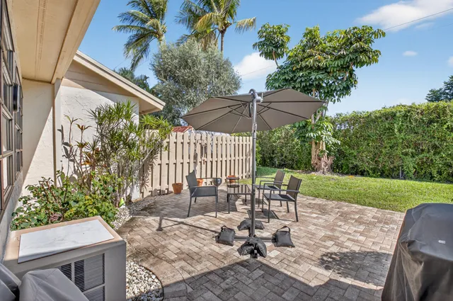 a view of a chair and table in backyard of the house