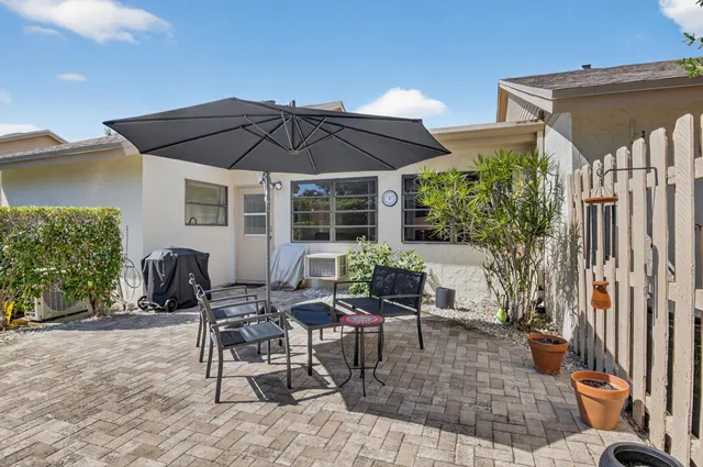 a view of backyard with outdoor seating a patio and plants