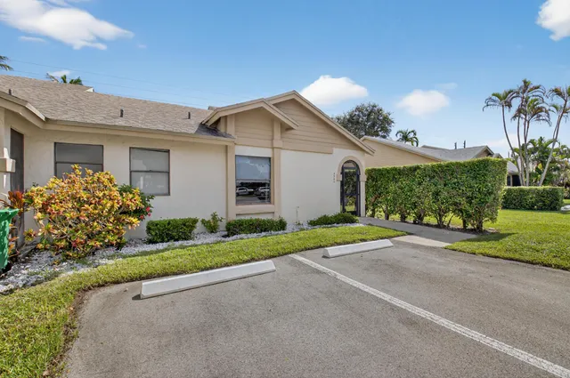 a view of a house with a yard and large tree
