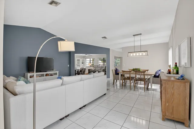 a living room with furniture a dining table and a large window