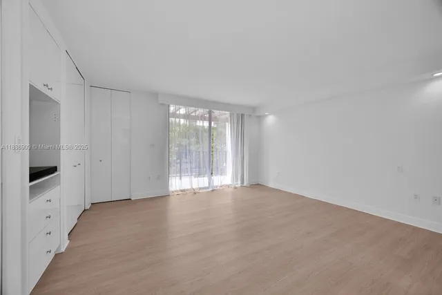 a view of an empty room with a kitchen