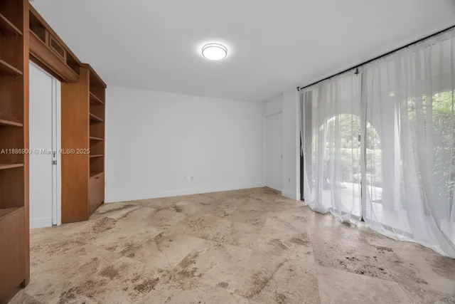a view of a big room with windows and chandelier fan