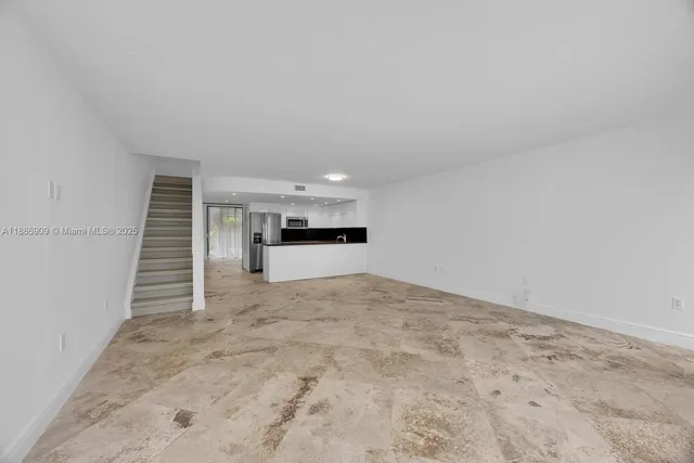 a view of empty room with kitchen