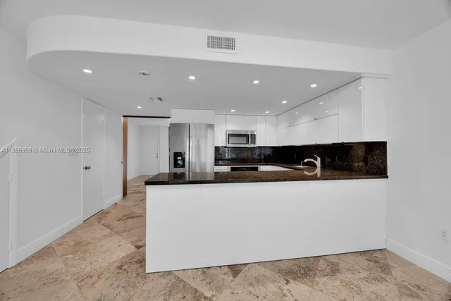 a view of kitchen with stainless steel appliances kitchen island sink and stove
