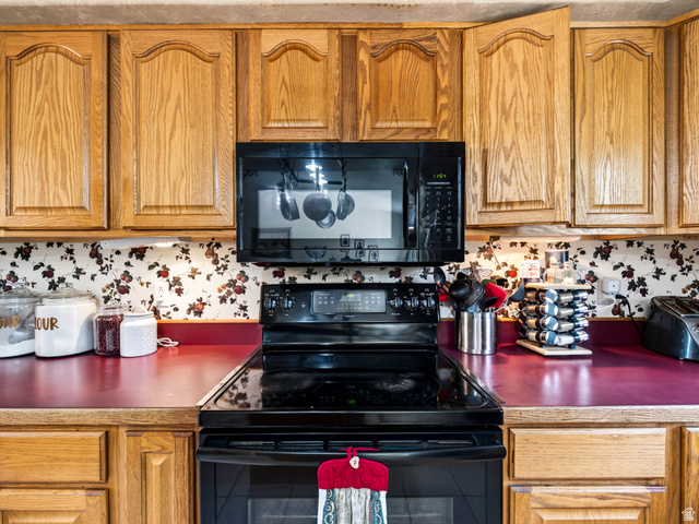 4380 Main Street Logan, UT 84321 - Photo 25 of 74 Wood cabinetry, black over-the-range microwave, black electric range, and red countertops