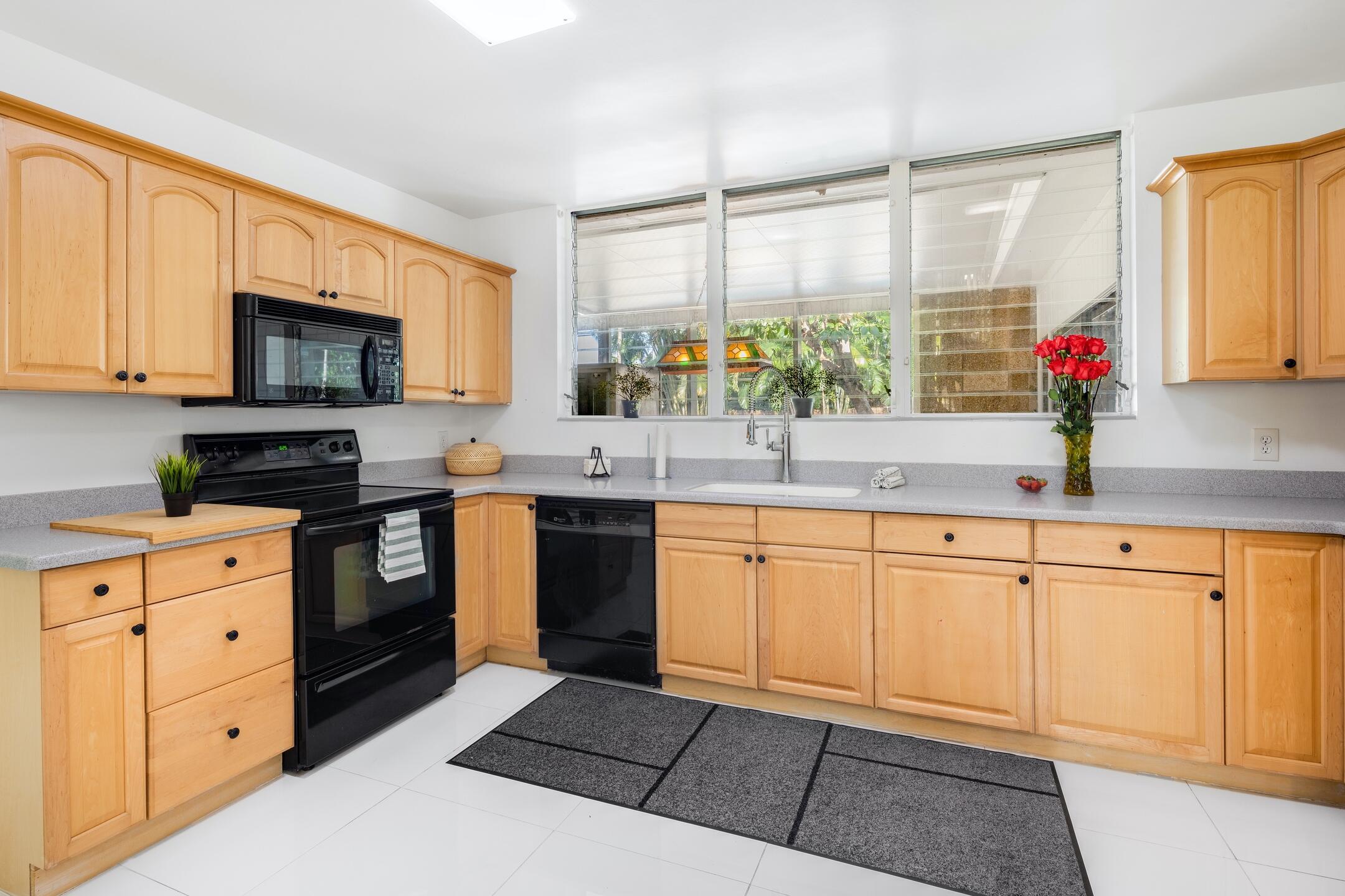 7306 Clarke Road Lake Clarke Shores, FL 33406 - Photo 19 of 36 a kitchen with granite countertop a sink stainless steel appliances and cabinets
