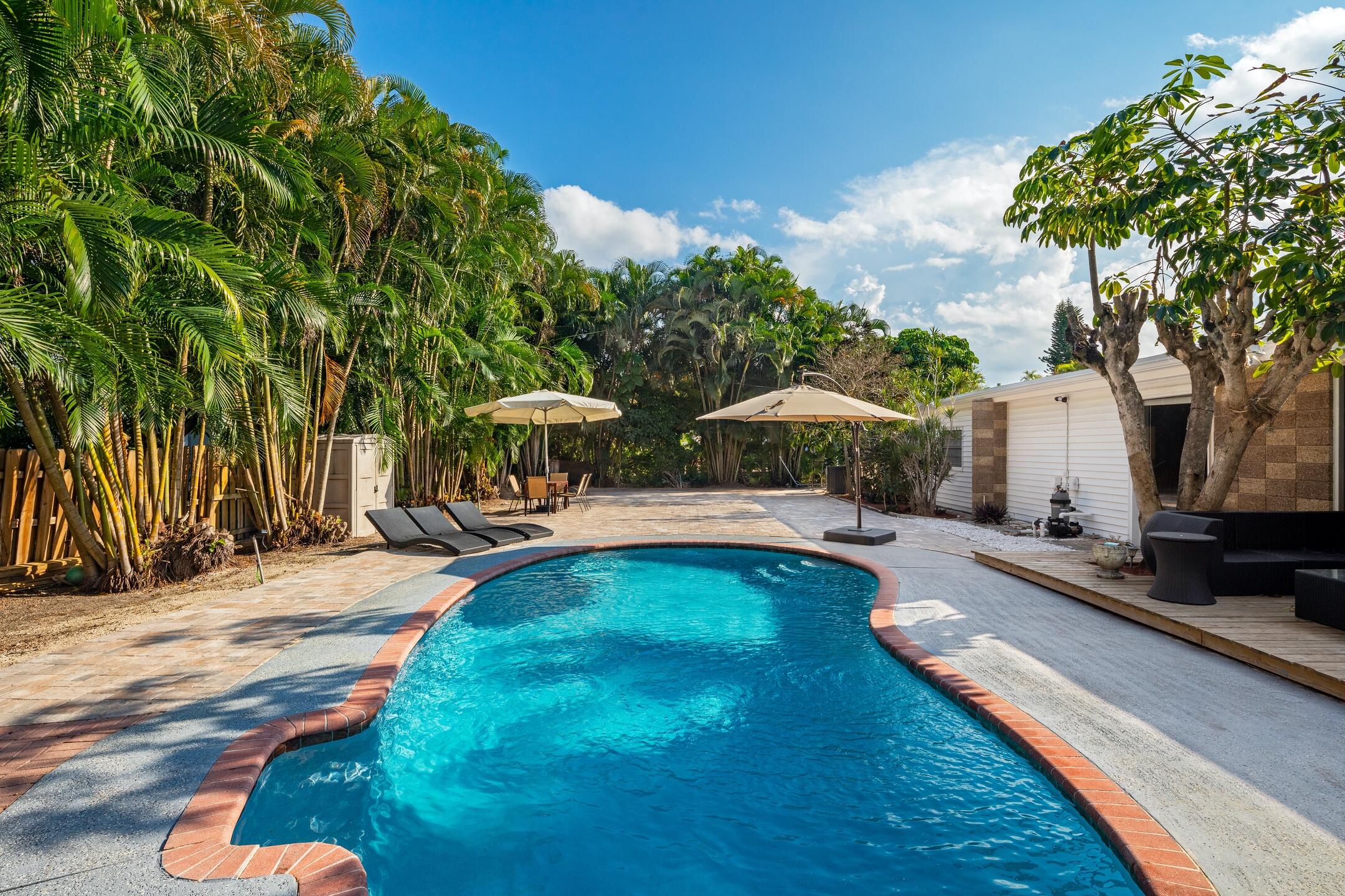 7306 Clarke Road Lake Clarke Shores, FL 33406 - Photo 6 of 36 a view of swimming pool with lawn chairs and plants