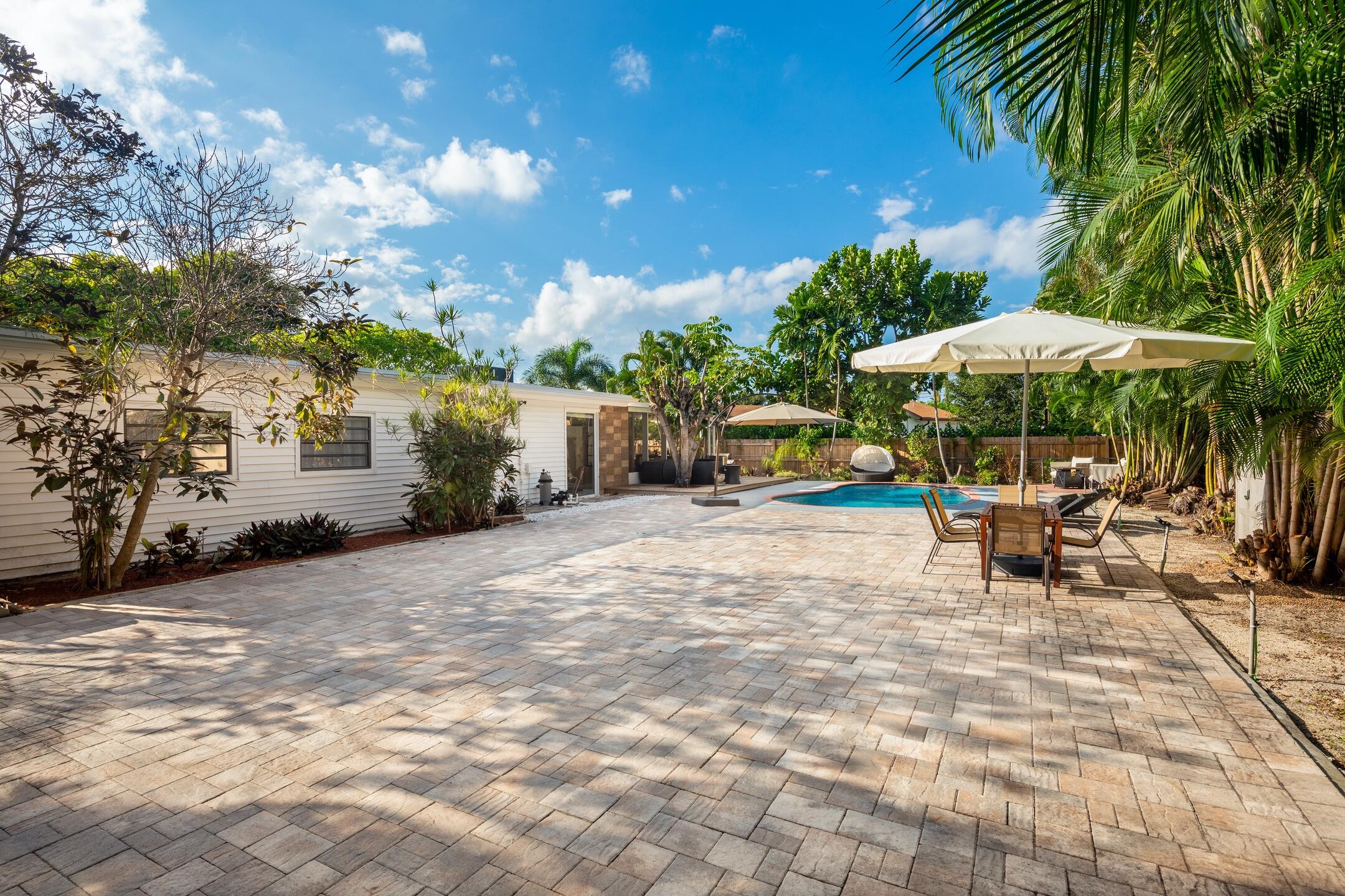 7306 Clarke Road Lake Clarke Shores, FL 33406 - Photo 9 of 36 a view of a patio with a table and chairs under an umbrella