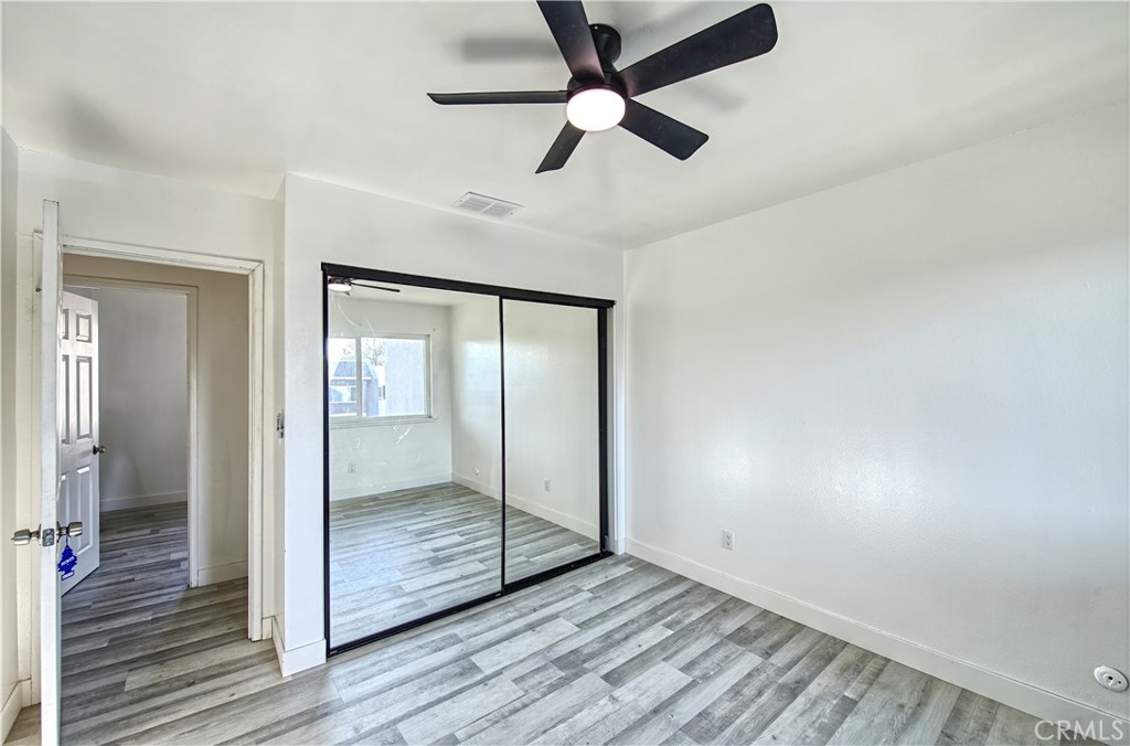 474 West Jackson Street Rialto, CA 92376 - Photo 10 of 14 an empty room with wooden floor fan and windows