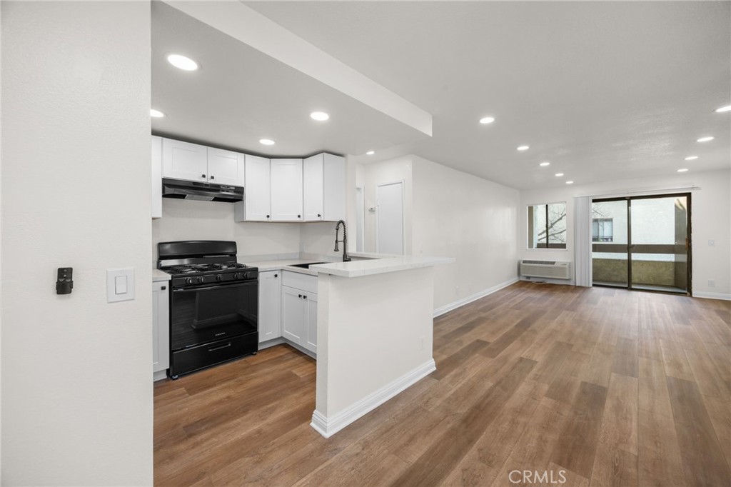 600 West 3rd Street, Unit B205 Santa Ana, CA 92701 - Photo 3 of 34 a kitchen with granite countertop a stove top oven and cabinets
