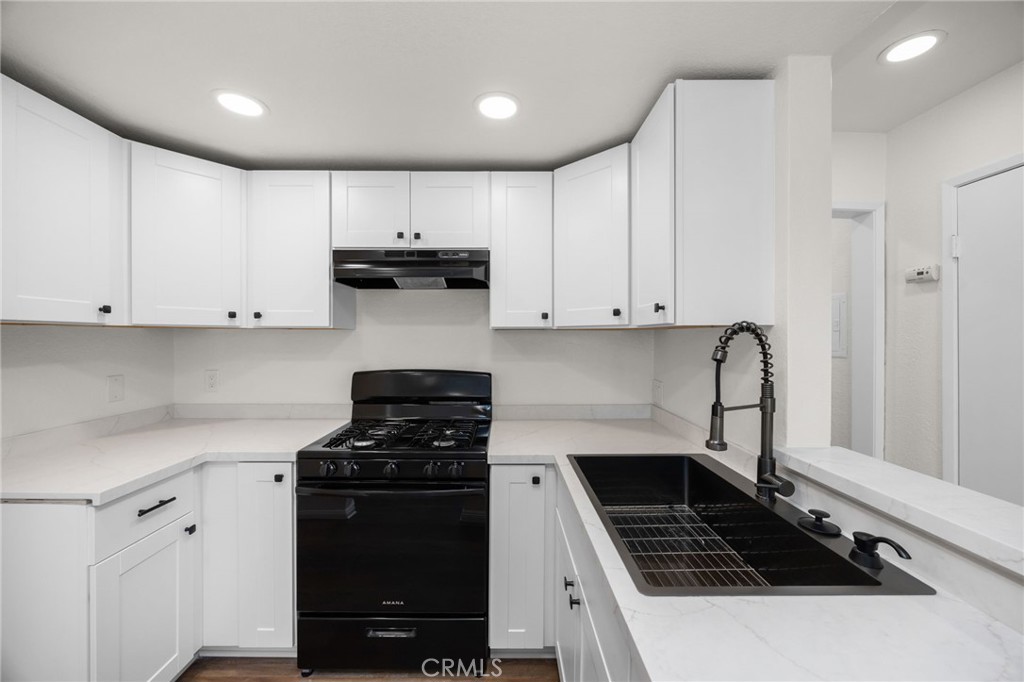 600 West 3rd Street, Unit B205 Santa Ana, CA 92701 - Photo 5 of 34 a kitchen with granite countertop a stove and a refrigerator