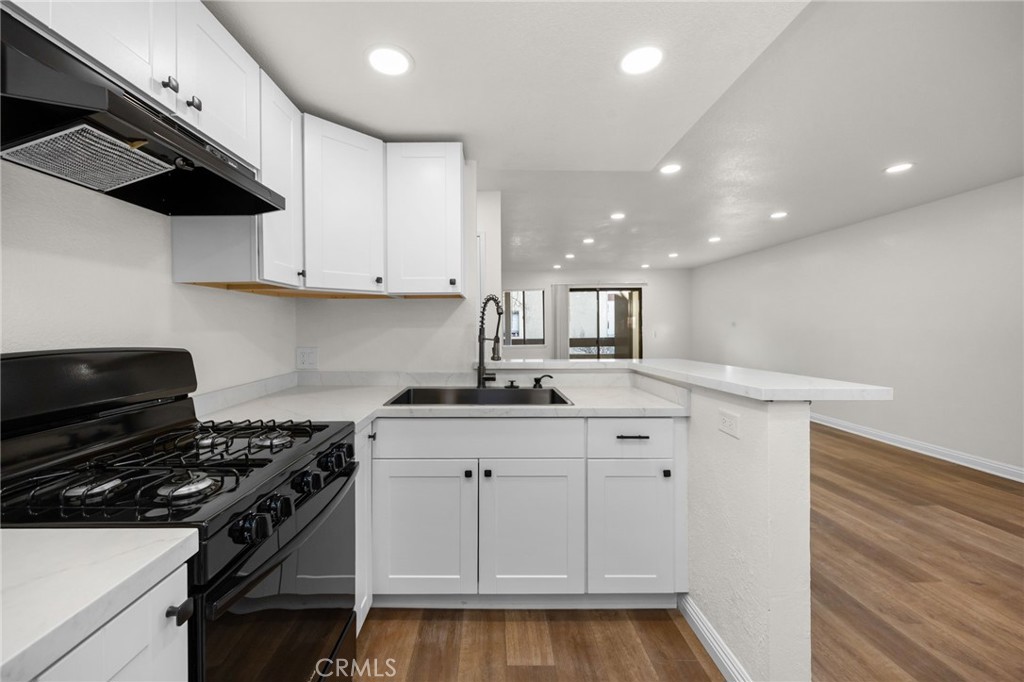 600 West 3rd Street, Unit B205 Santa Ana, CA 92701 - Photo 9 of 34 a kitchen with a sink a stove and cabinets