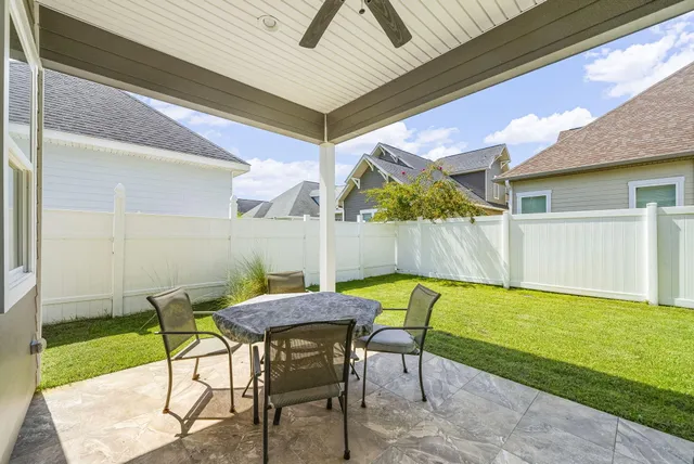 a view of a patio with table and chairs with wooden floor and a yard