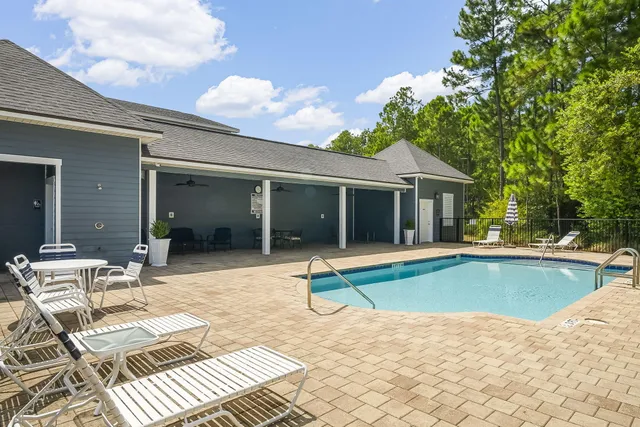 a view of house with swimming pool and sitting area
