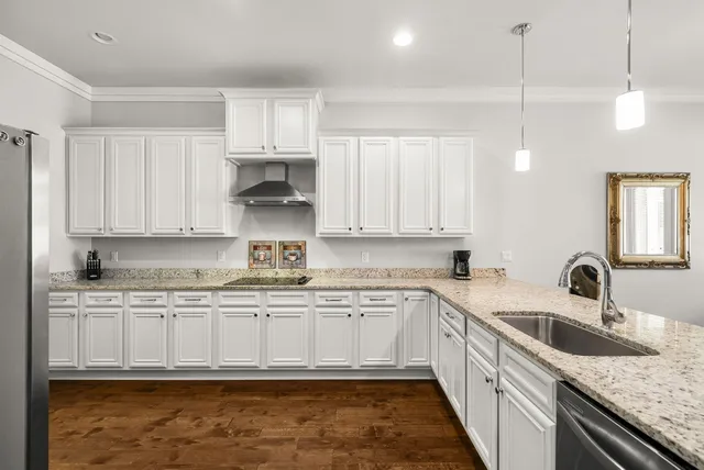 a kitchen with granite countertop a sink a stove and cabinets
