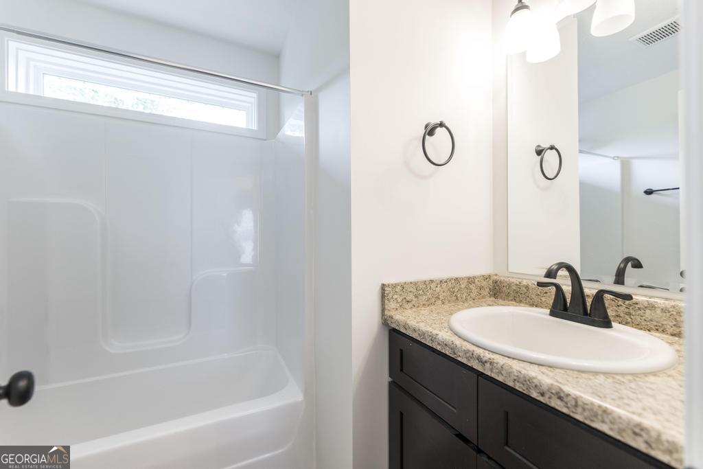 180 Ward Street Macon, GA 31204 - Photo 18 of 26 a bathroom with a granite countertop sink a mirror and a bathtub