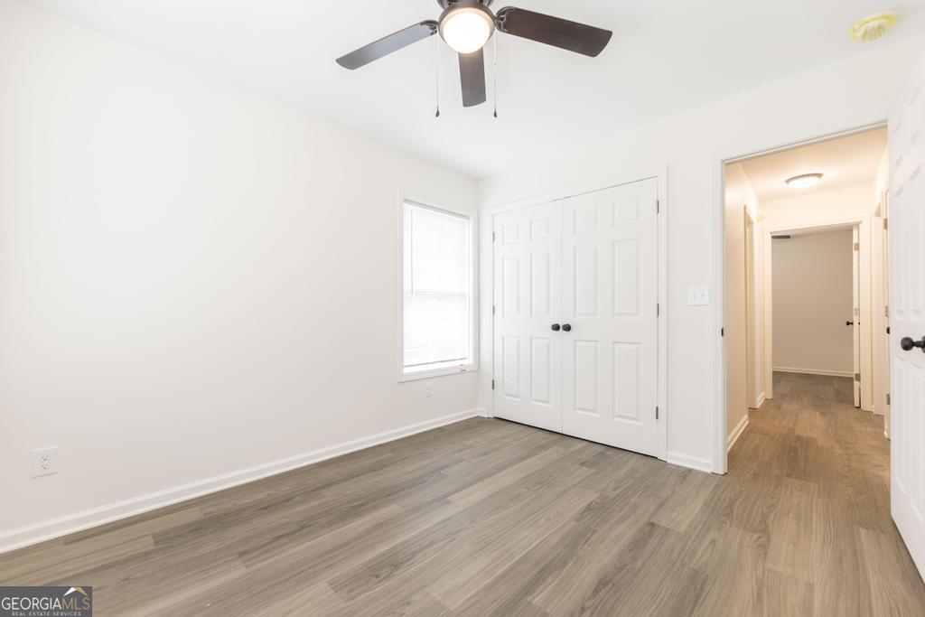 180 Ward Street Macon, GA 31204 - Photo 20 of 26 an empty room with wooden floor chandelier fan and windows