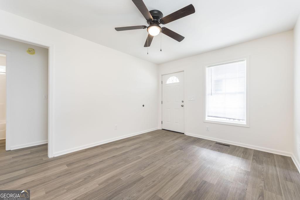 180 Ward Street Macon, GA 31204 - Photo 6 of 26 an empty room with wooden floor ceiling fan and windows