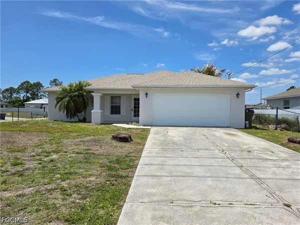 a view of a white house with a yard