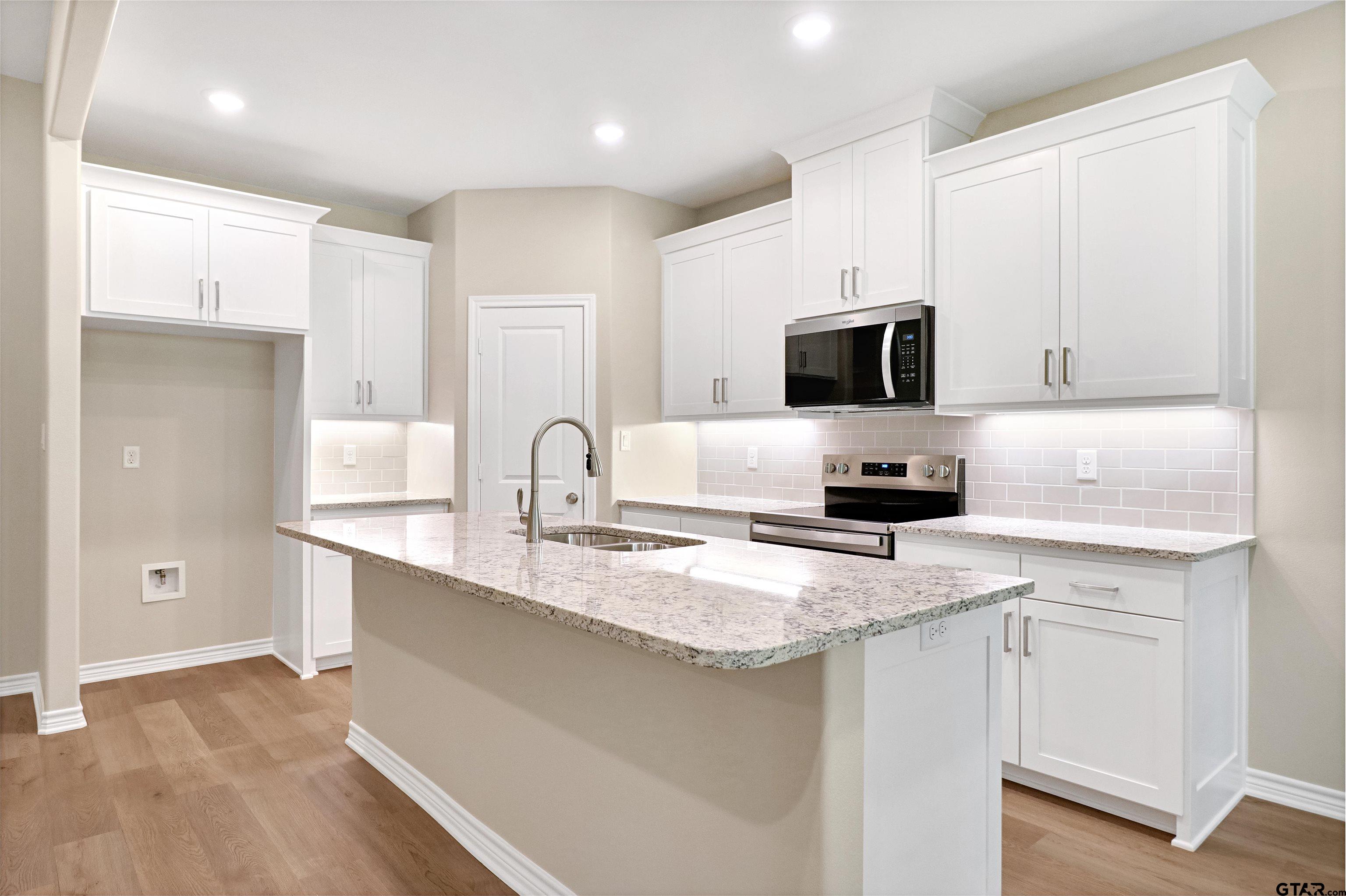 3053 Guinn Farms Road Tyler, TX 75707 - Photo 7 of 32 a kitchen with a sink stove and refrigerator