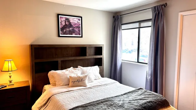 a bedroom with a bed and dresser with mirror