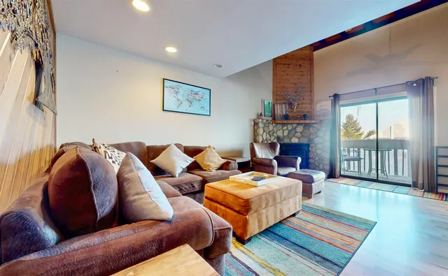 a living room with fireplace furniture and a rug