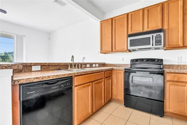 a kitchen with granite countertop cabinets stainless steel appliances and a counter space