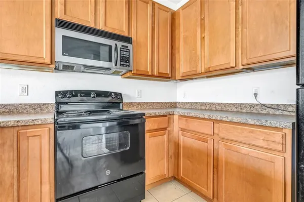 a kitchen with stainless steel appliances granite countertop a stove microwave and cabinets