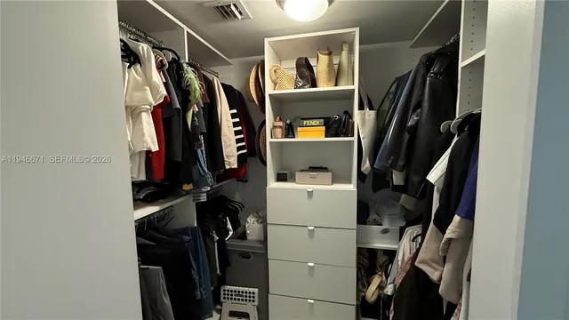 a view of walk in closet with clothes and shoes