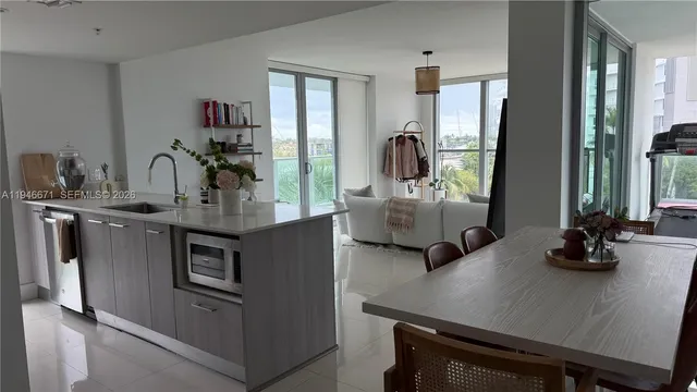 a kitchen with stainless steel appliances a sink a table and chairs
