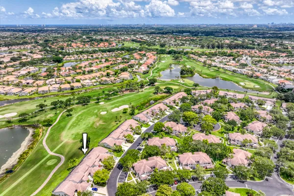 an aerial view of residential houses with outdoor space and trees