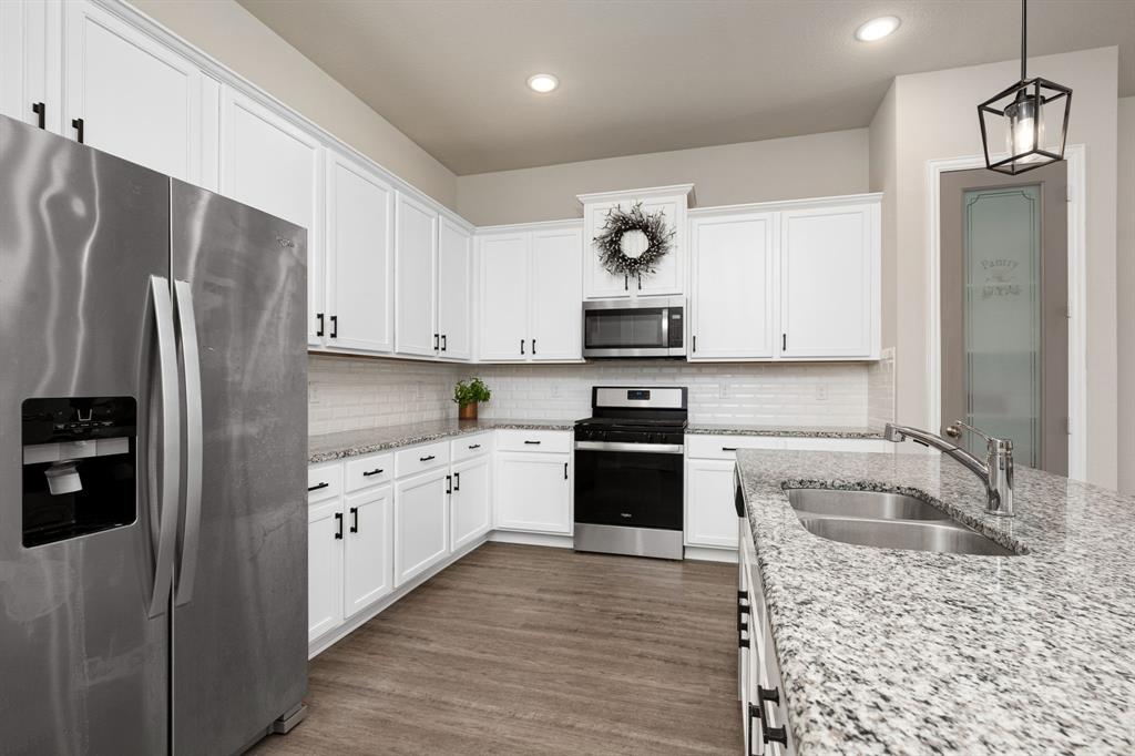 1320 Rosebush Road Aubrey, TX 76227 - Photo 9 of 33 a kitchen with granite countertop a refrigerator stove and sink