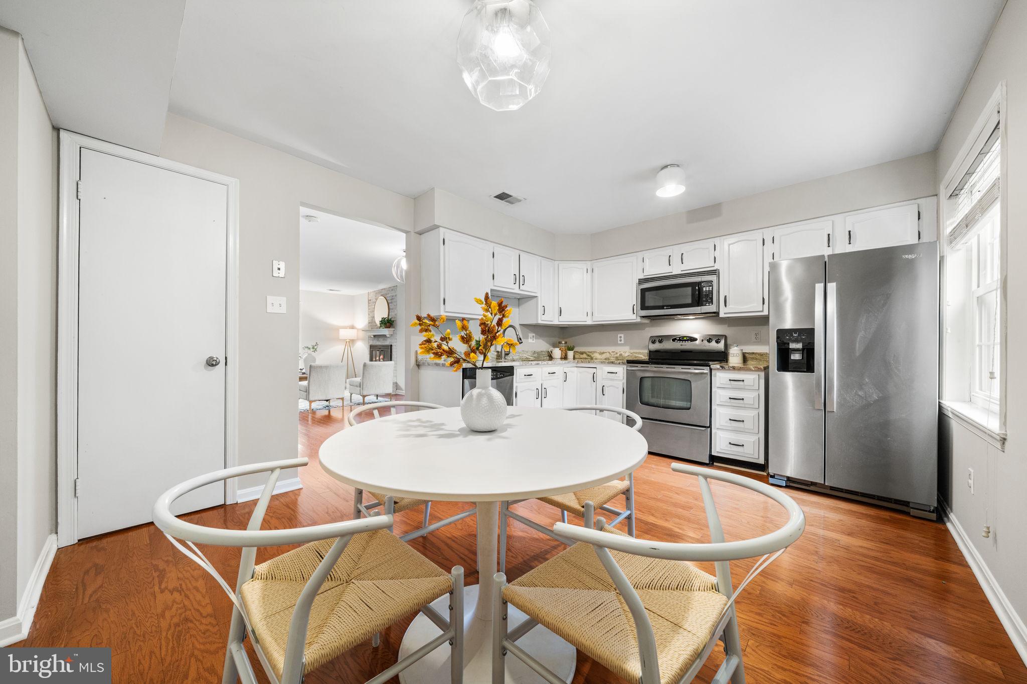 4931 7th Road South, Unit 4931 Arlington, VA 22204 - Photo 12 of 25 a kitchen with stainless steel appliances granite countertop a dining table chairs refrigerator and microwave