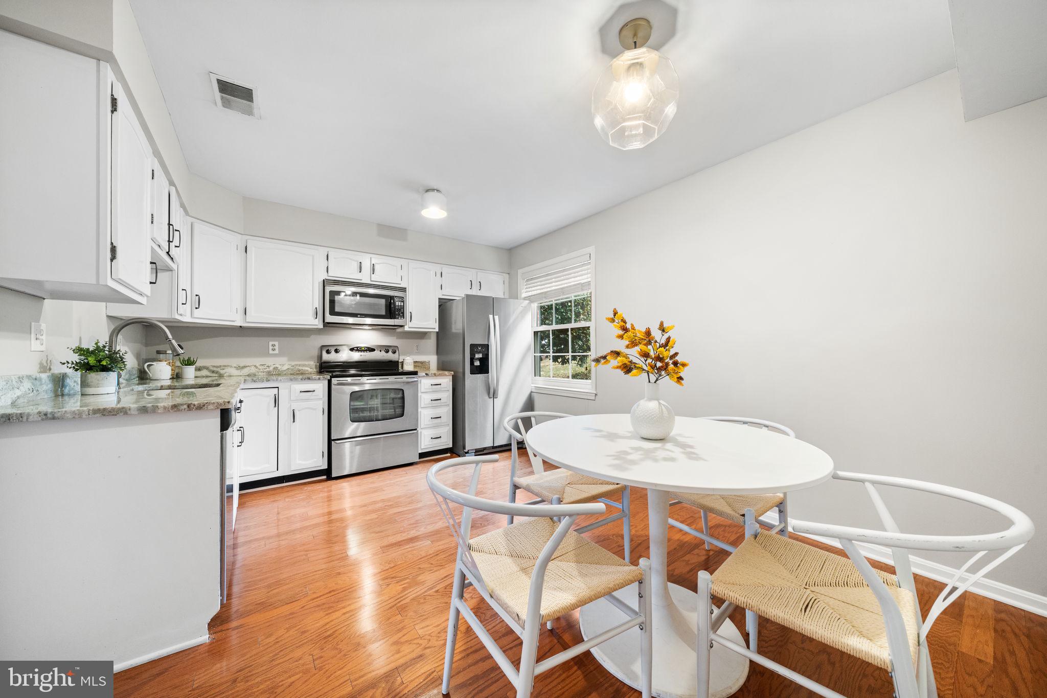 4931 7th Road South, Unit 4931 Arlington, VA 22204 - Photo 10 of 25 a kitchen with stainless steel appliances a dining table chairs and granite counter tops