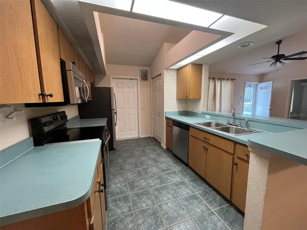 a large kitchen with granite countertop a sink and a refrigerator