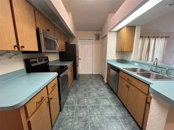 a kitchen with stainless steel appliances a sink stove and cabinets