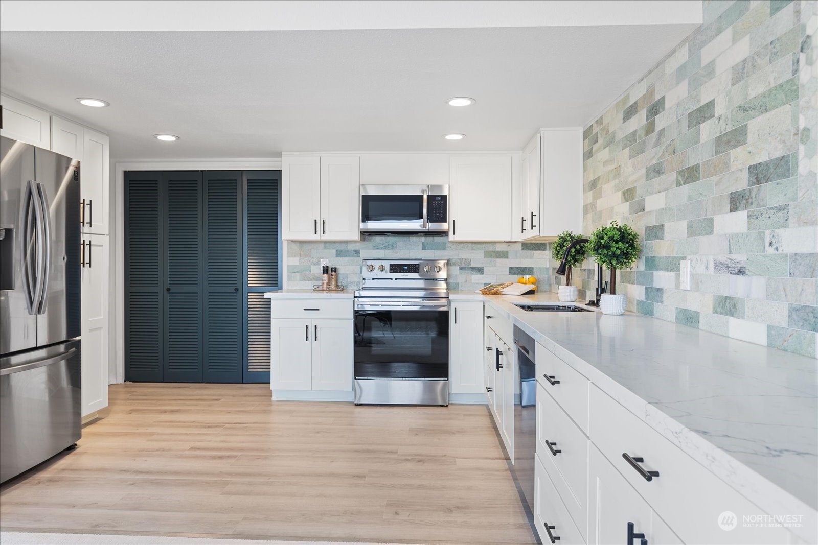 655 Main Street, Unit 202 Edmonds, WA 98020 - Photo 14 of 40 a kitchen with stainless steel appliances granite countertop a refrigerator and a stove top oven