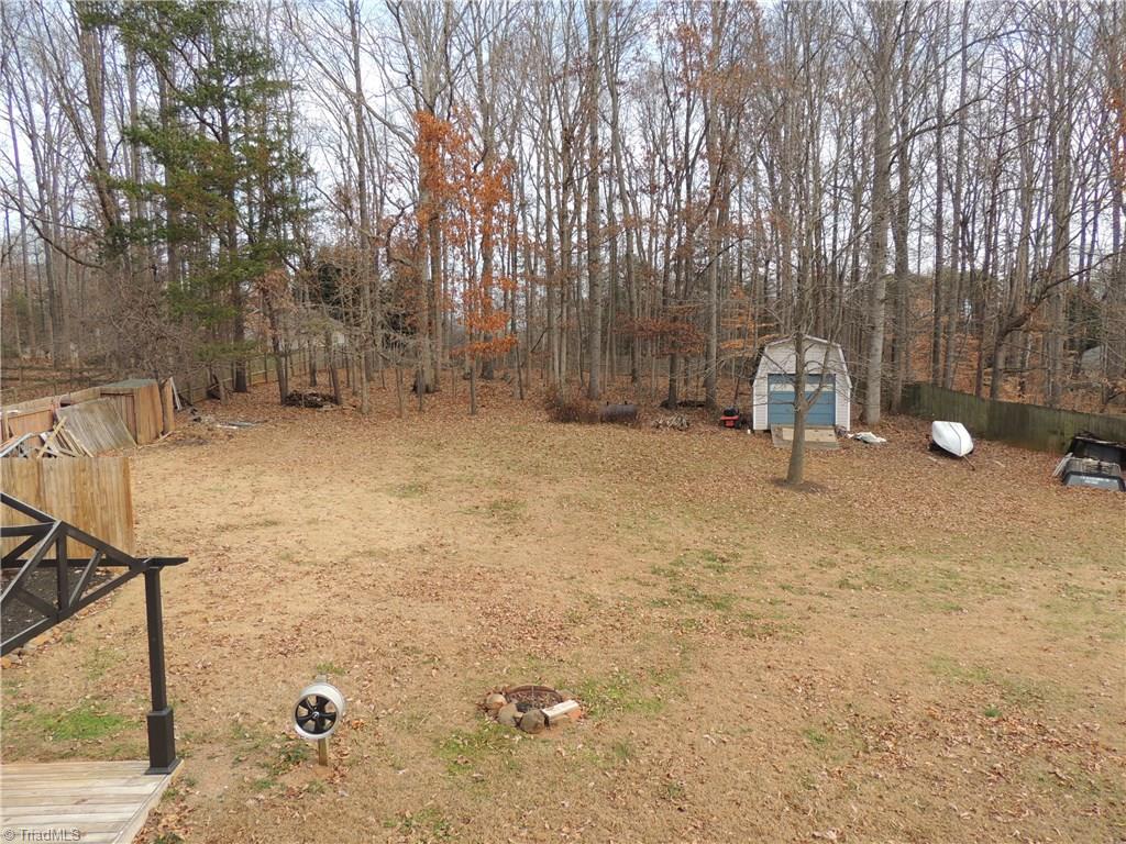 7606 Keating Drive Oak Ridge, NC 27310 - Photo 30 of 30 Backyard showing cleared and wooded area with privacy fence