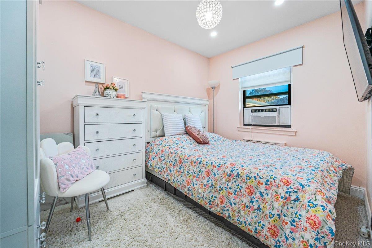 217-08 73rd Avenue, Unit 383A2 Queens, NY 11364 - Photo 12 of 24 a bedroom with a bed a table and chair