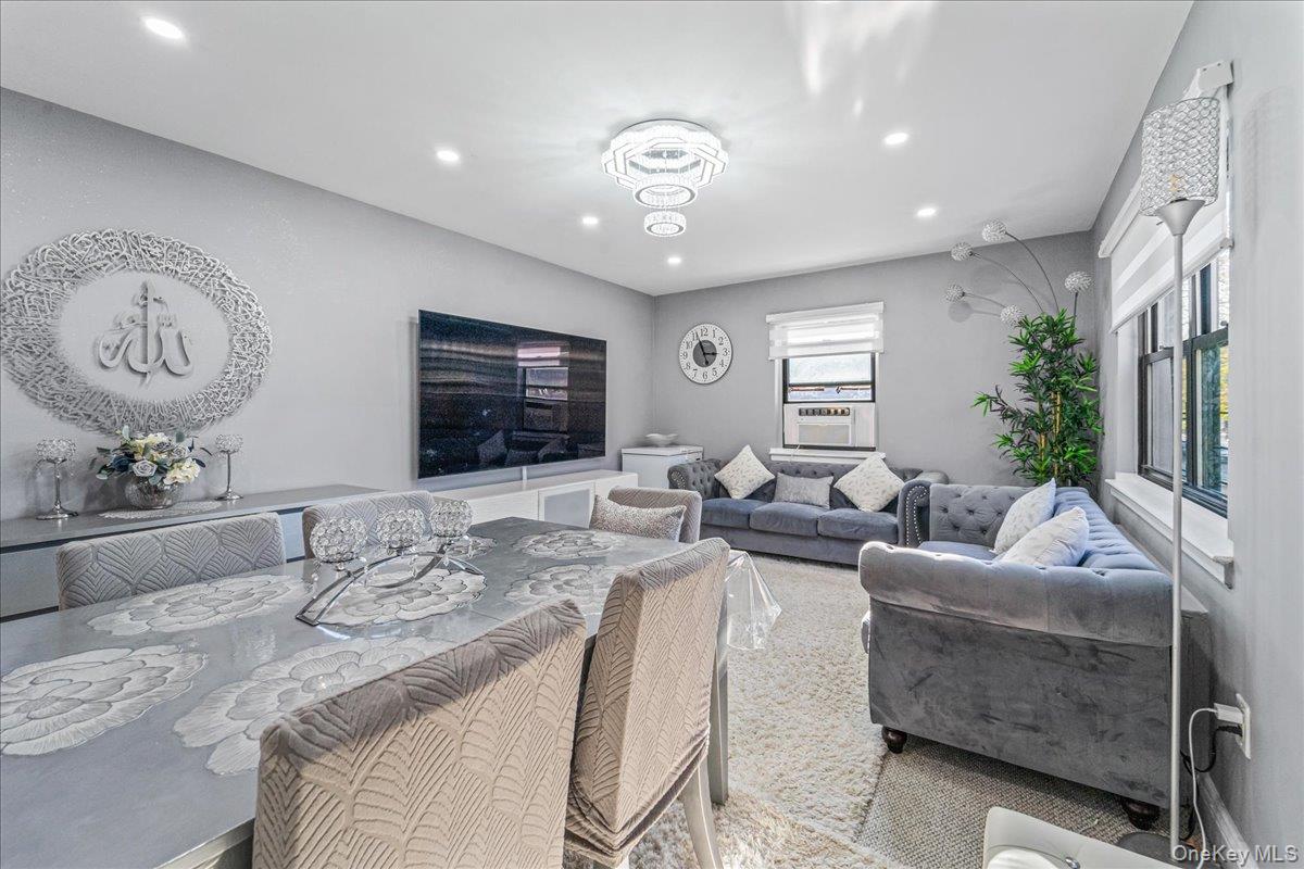 217-08 73rd Avenue, Unit 383A2 Queens, NY 11364 - Photo 5 of 24 a living room with furniture potted plant and a large mirror
