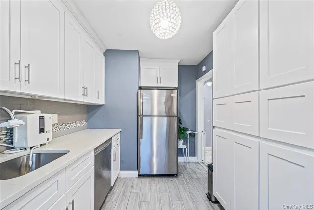 a kitchen with a refrigerator sink and cabinets