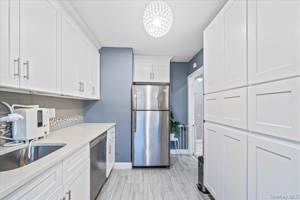 217-08 73rd Avenue, Unit 383A2 Queens, NY 11364 - Photo 9 of 24 a kitchen with a refrigerator sink and cabinets