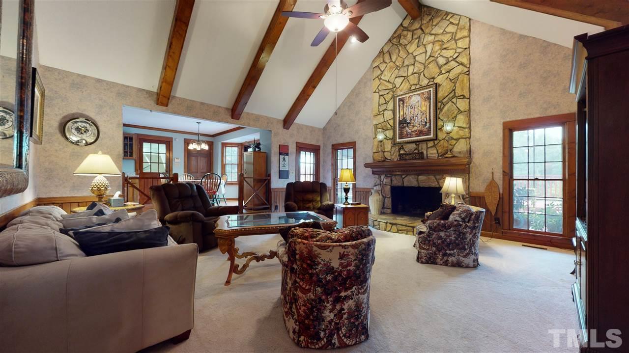 7010 Farmdale Road Raleigh, NC 27610 - Photo 17 of 30 a living room with furniture a fireplace and a floor to ceiling window