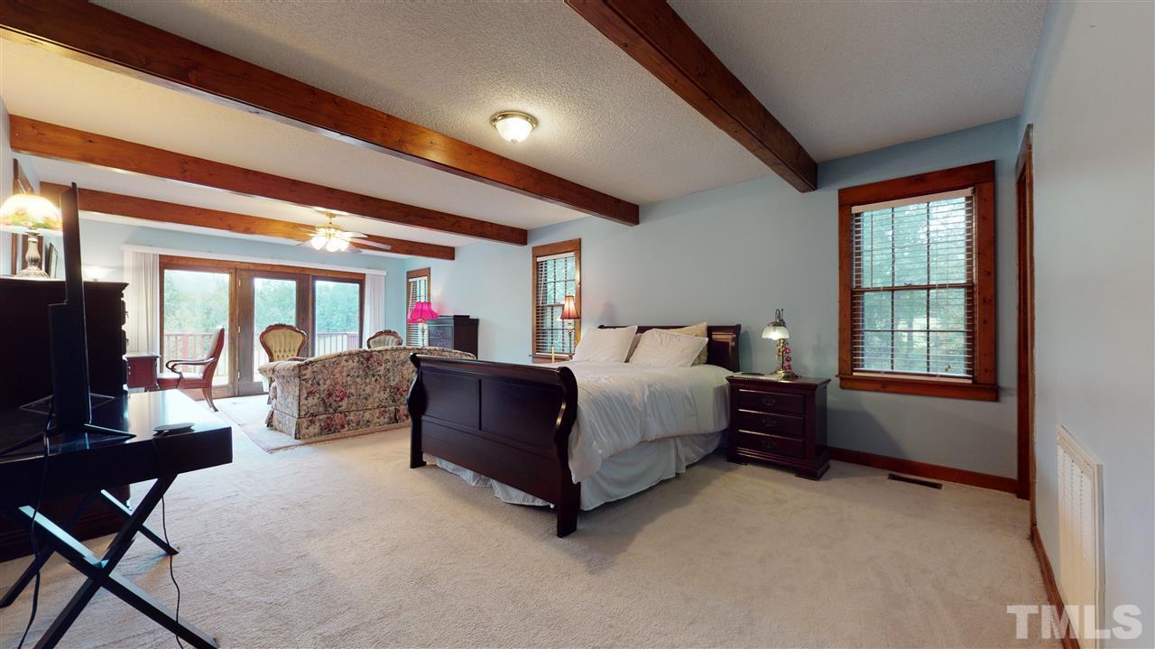 7010 Farmdale Road Raleigh, NC 27610 - Photo 20 of 30 a bedroom with a bed wooden floor and a flat screen tv